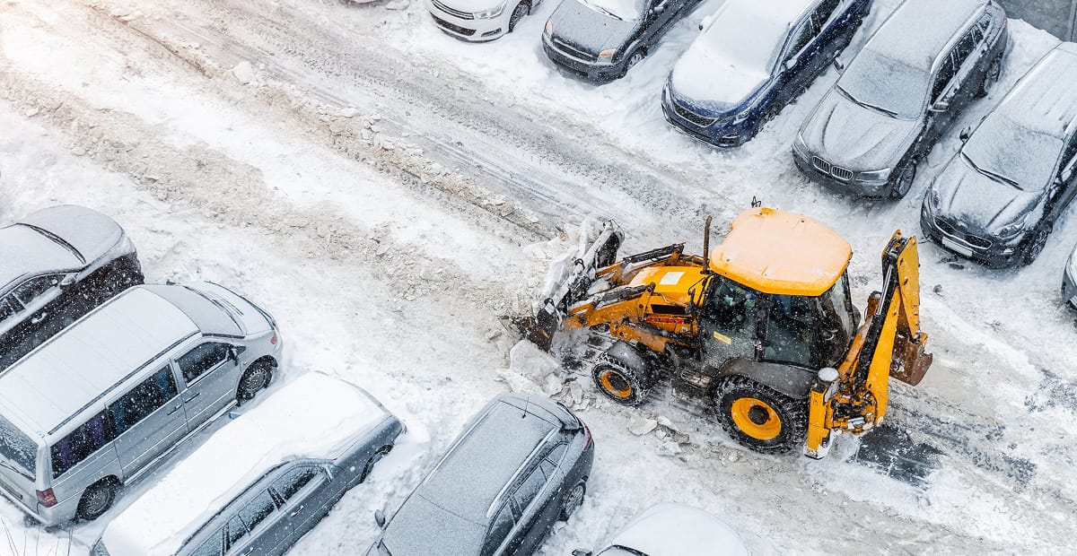 Snowplow clearing parking lot after snowstorm