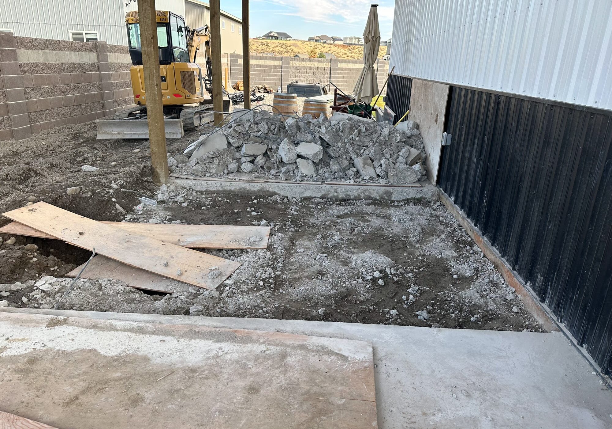 Construction site with digger and rubble pile.