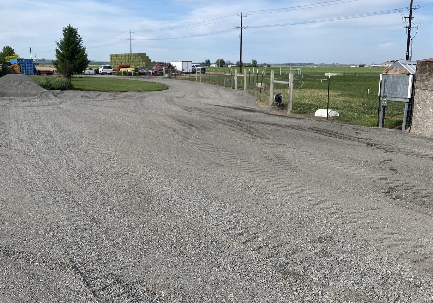 Gravel road with fields and sky backdrop.